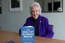 Dr Doreen Miller with copies of her book The Healthy Business Bridge