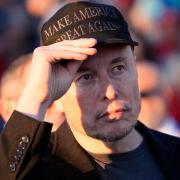 Elon Musk listens as Republican presidential nominee Donald Trump speaks at a campaign event (Alex Brandon/AP)